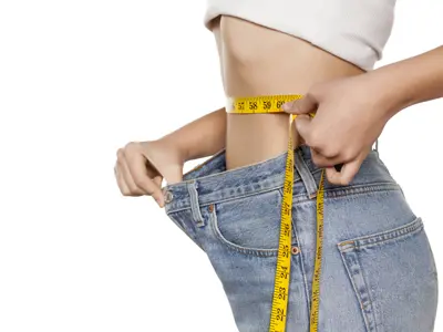 Woman with measuring tape showing weight loss